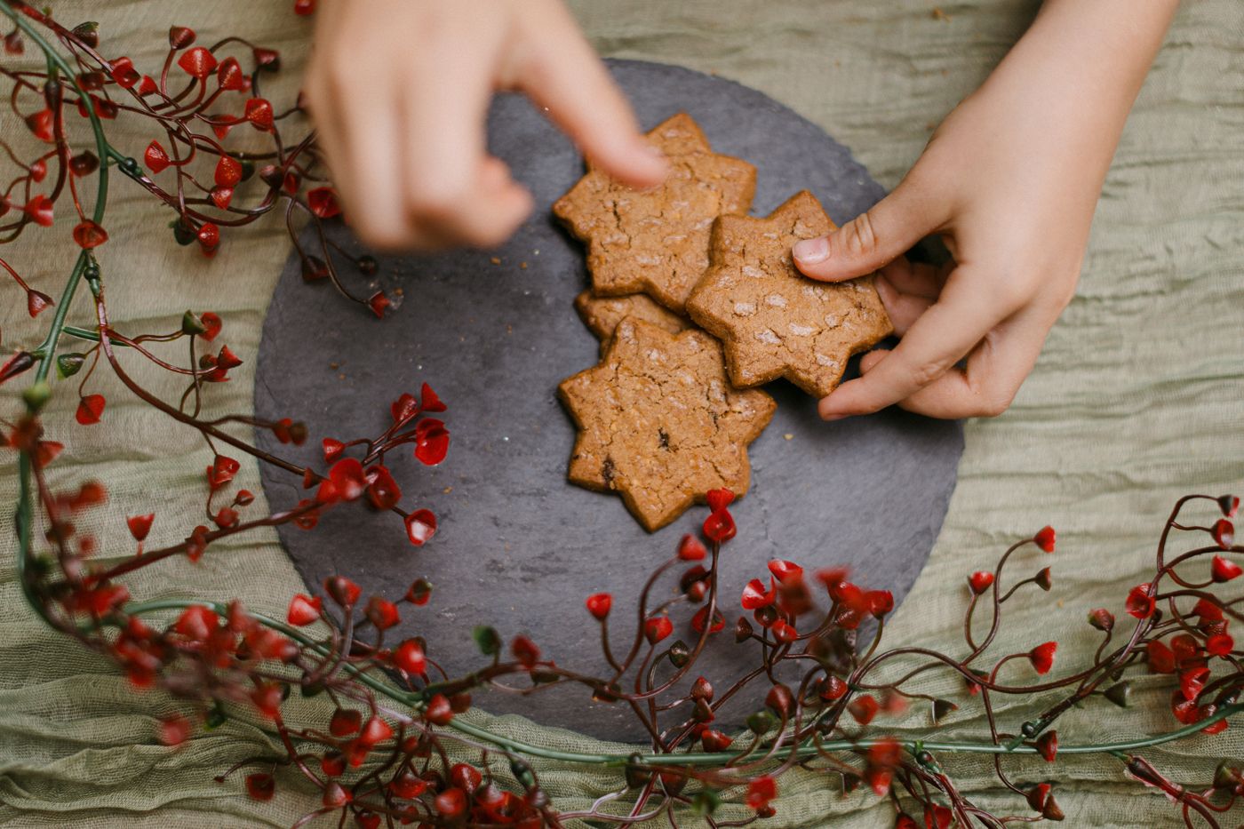 Kinderhände greifen nach Weihnachtskeksen